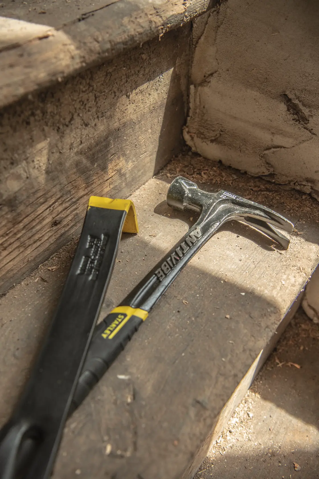 STANLEY 55-515 pry bar and hammer on wooden steps, close-up angle.