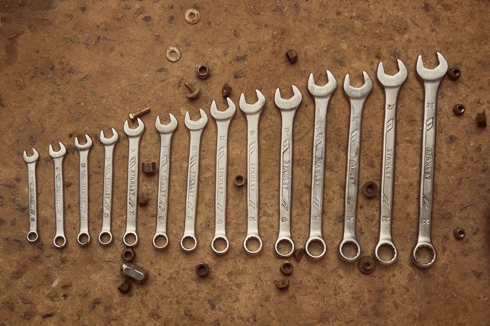 STANLEY STMT72828 wrench set photography showing thirteen wrenches in ascending size on a brown workbench.