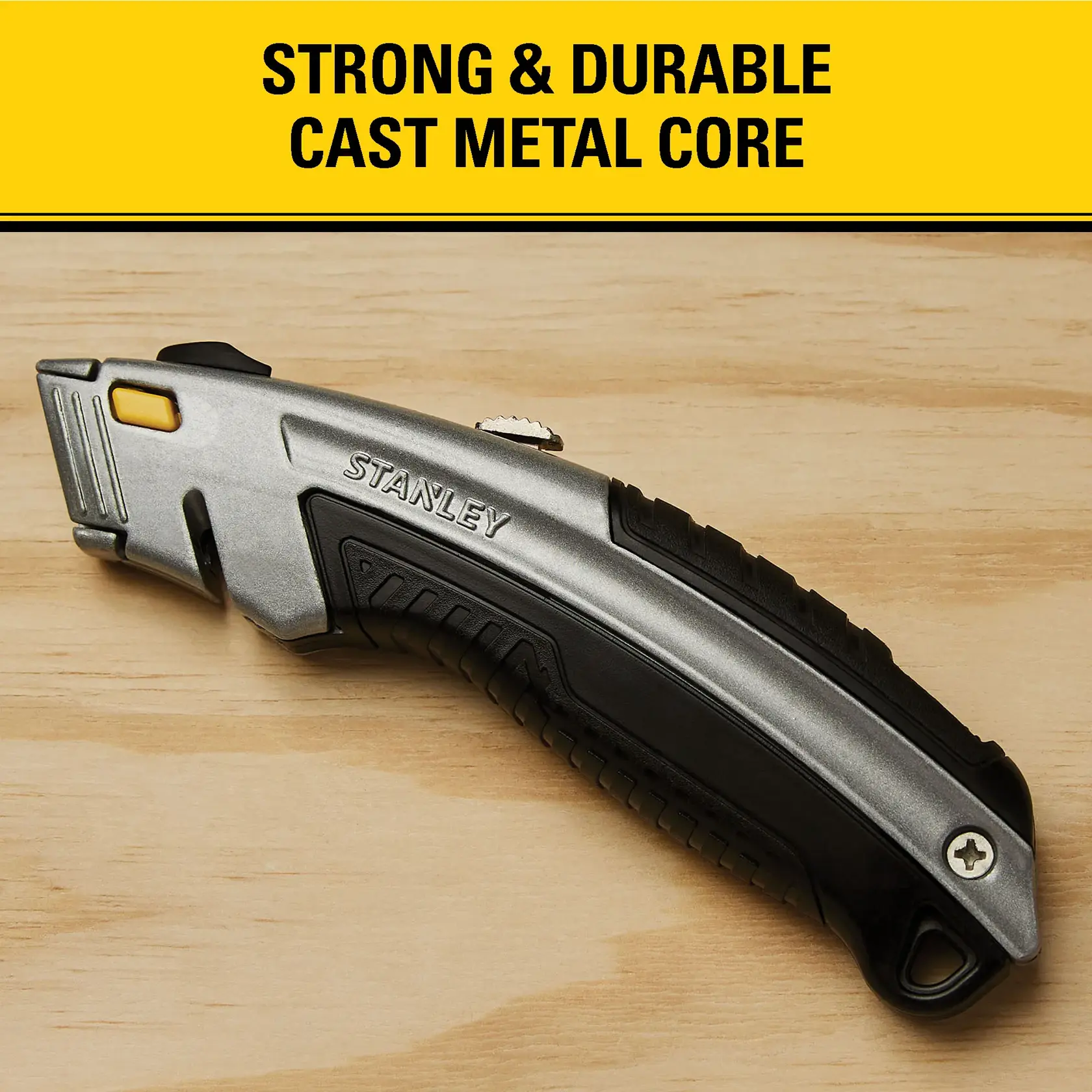 A Stanley utility knife with a strong and durable cast metal core, shown on a wooden surface. The knife features an ergonomic handle and safety lock.