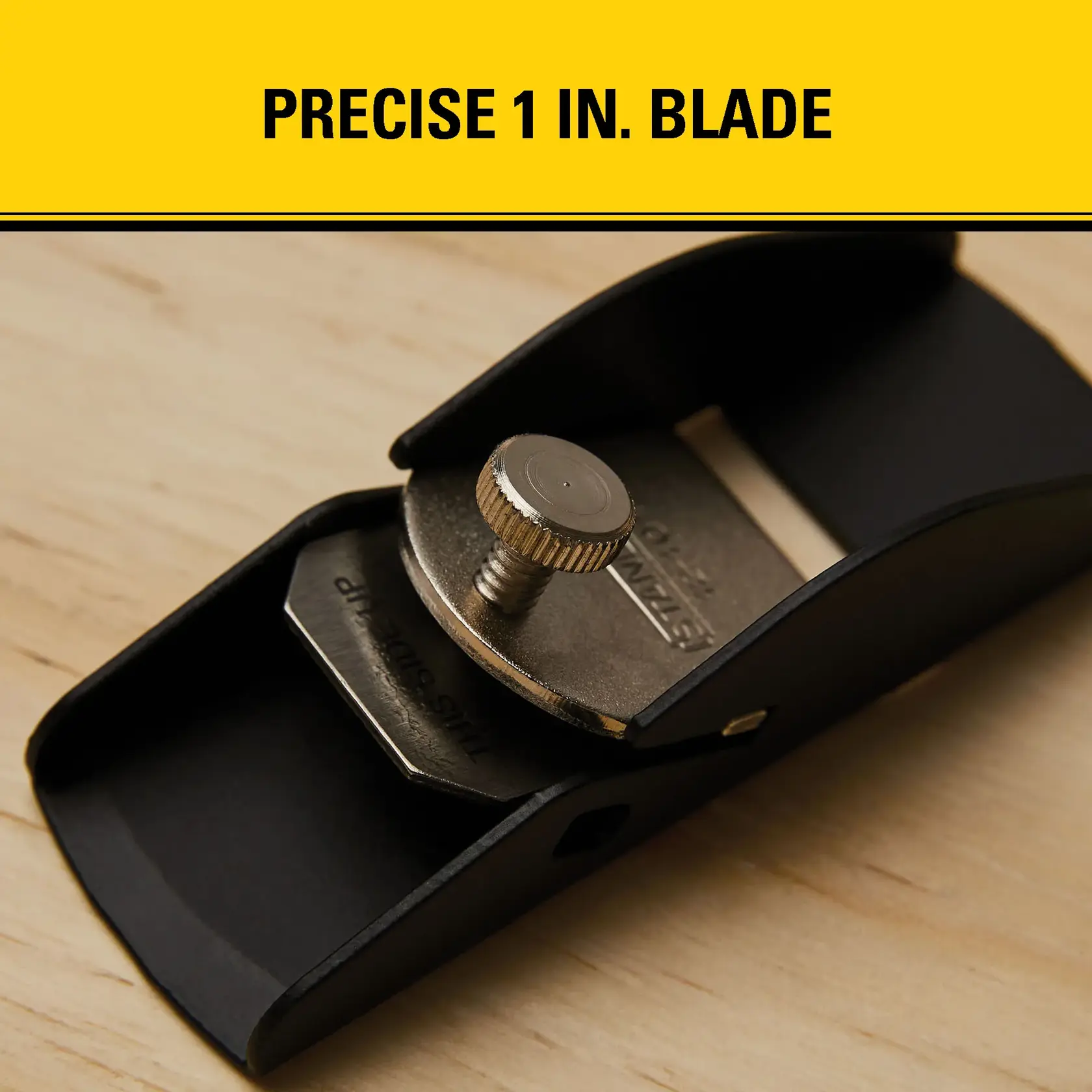Close-up of a STANLEY hand plane tool with a precise 1-inch blade, shown on a wooden surface. The tool features a metal blade adjustment knob and a compact black body.