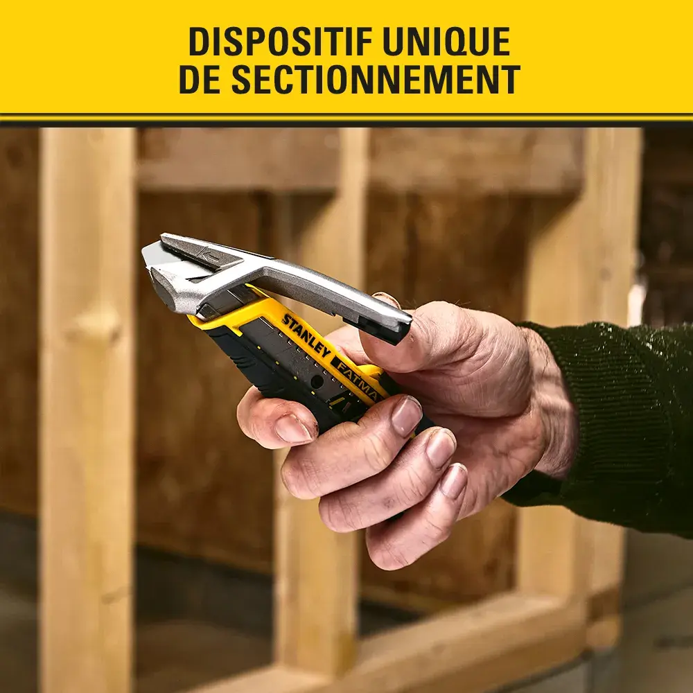Photo of STANLEY FMHT10592-0 utility knife in gloved hand cutting material, close-up view.