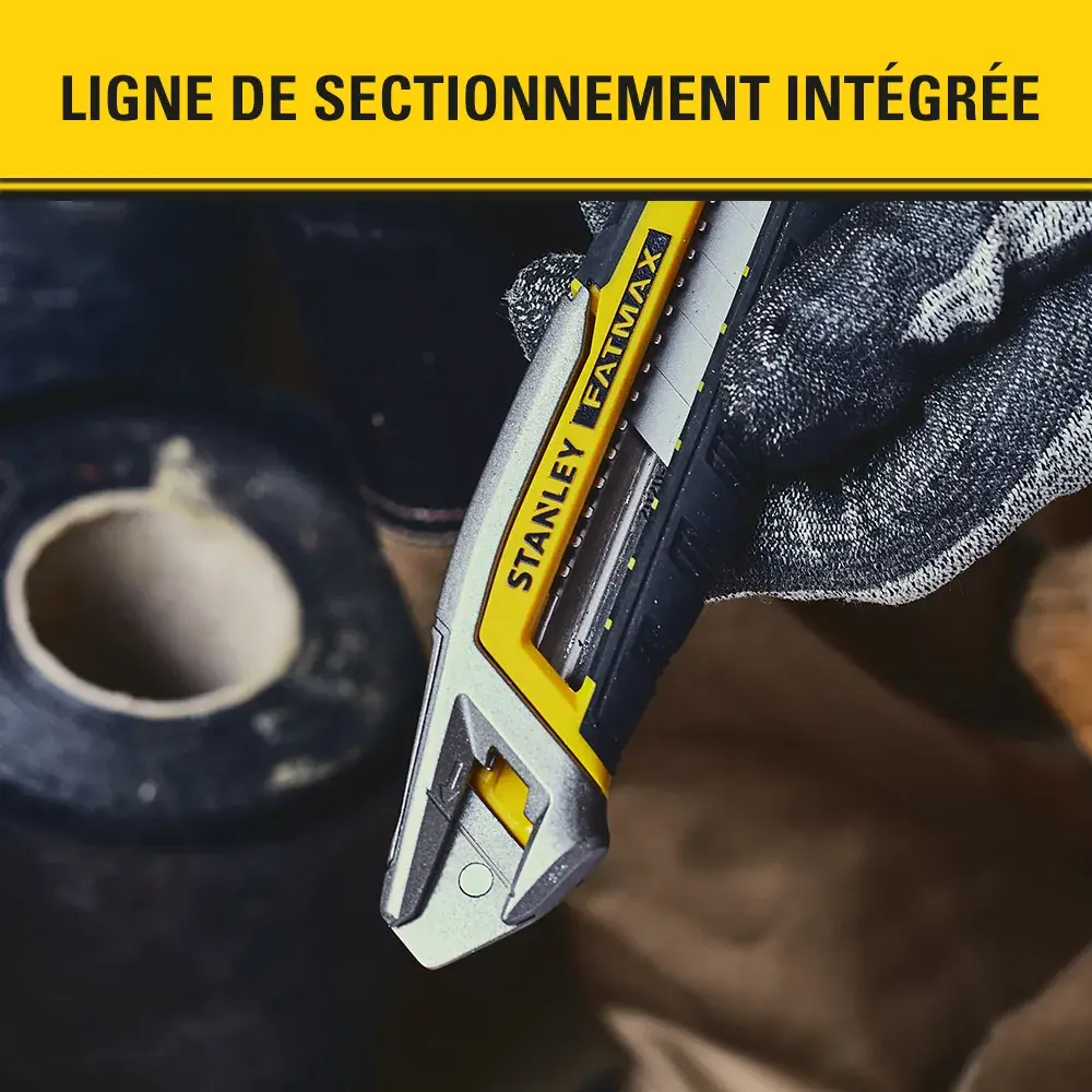 Stanley FMHT10592-0 utility knife cutting cardboard, shown in gloved hand, product photography.