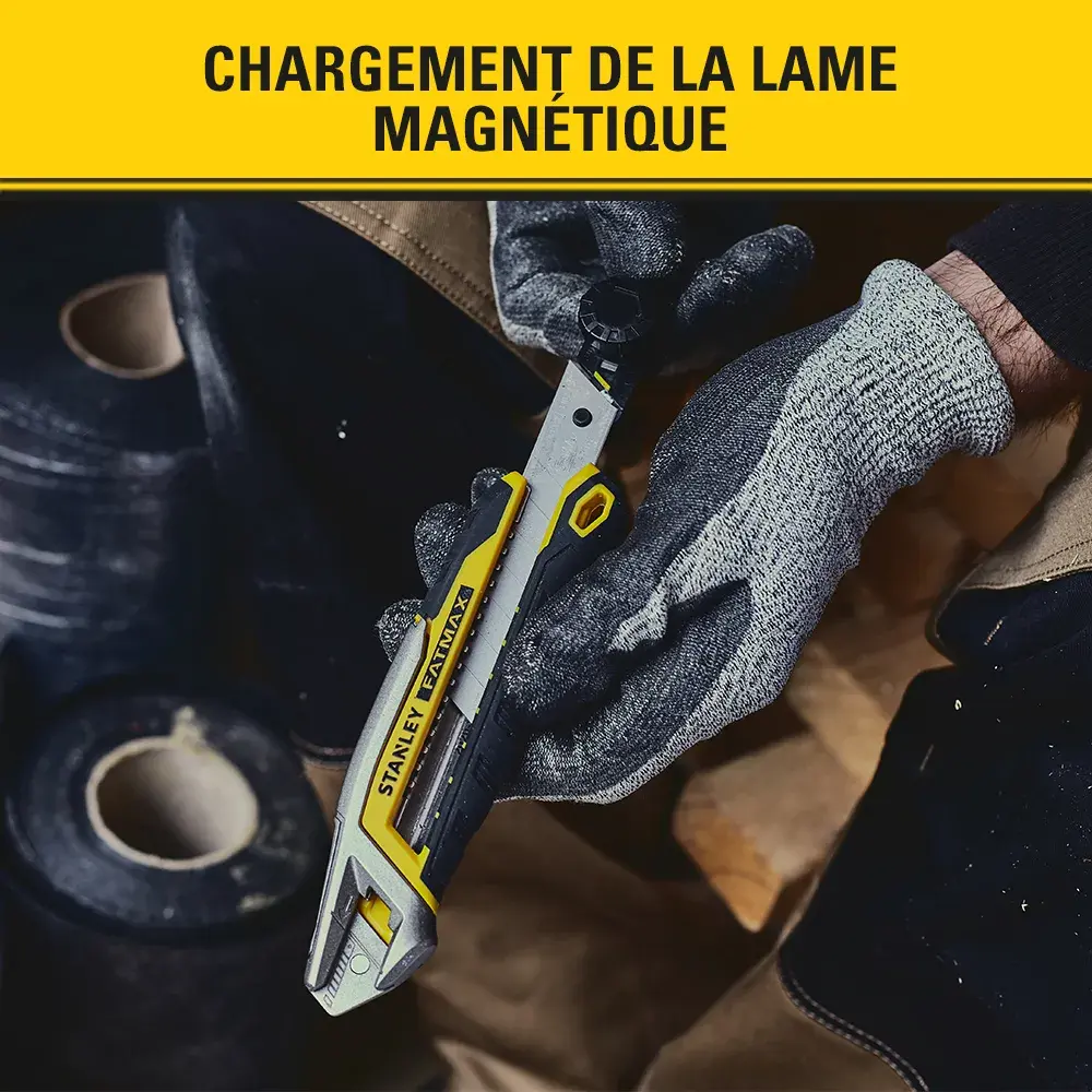 Stanley FMHT10592-0 utility knife cutting fabric with ruler, photography showing gloved hand in use.