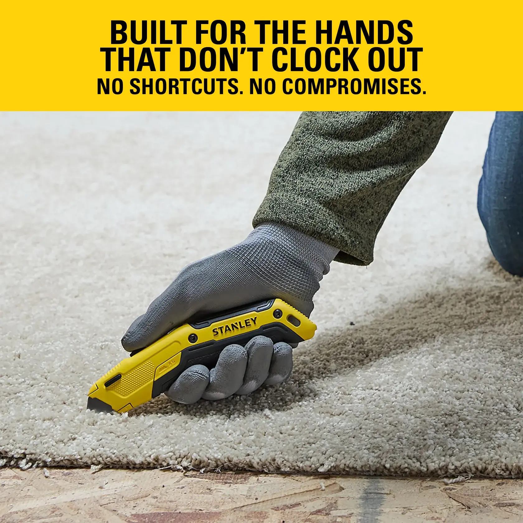 Stanley utility knife cutting carpet, gloved hand in action. Tool designed for hardworking solo use.