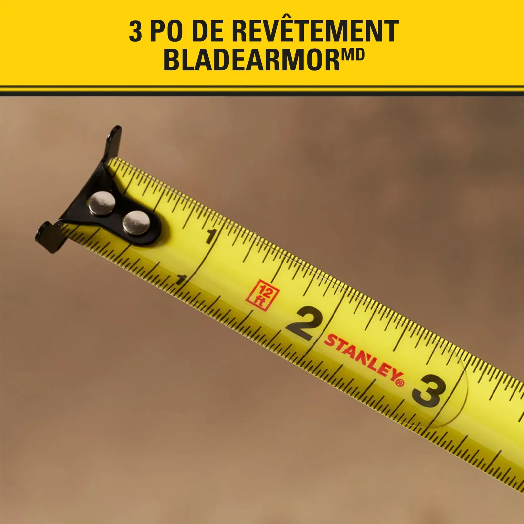 Gros plan sur un mètre ruban jaune STANLEY affichant des mesures en pouces, avec en haut le texte '3 PO DE REVÊTEMENT BLADEARMOR'.