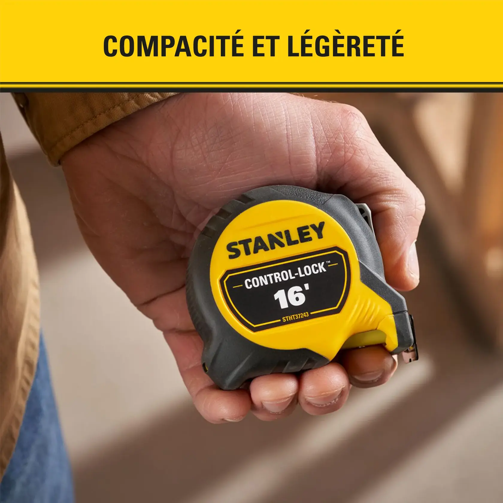 Une main tenant un mètre ruban Stanley Control-Lock de 16 pieds, avec un boîtier jaune et noir, mettant en avant la compacité et la légèreté.