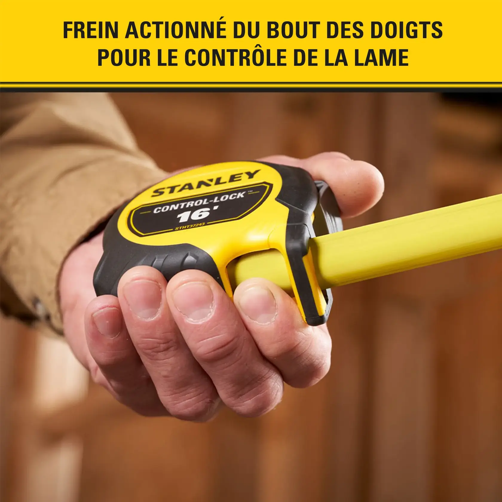Gros plan sur une main tenant un mètre ruban STANLEY Control-Lock de 16 pieds, avec un boîtier jaune et noir et un frein actionné du bout des doigts pour le contrôle de la lame.
