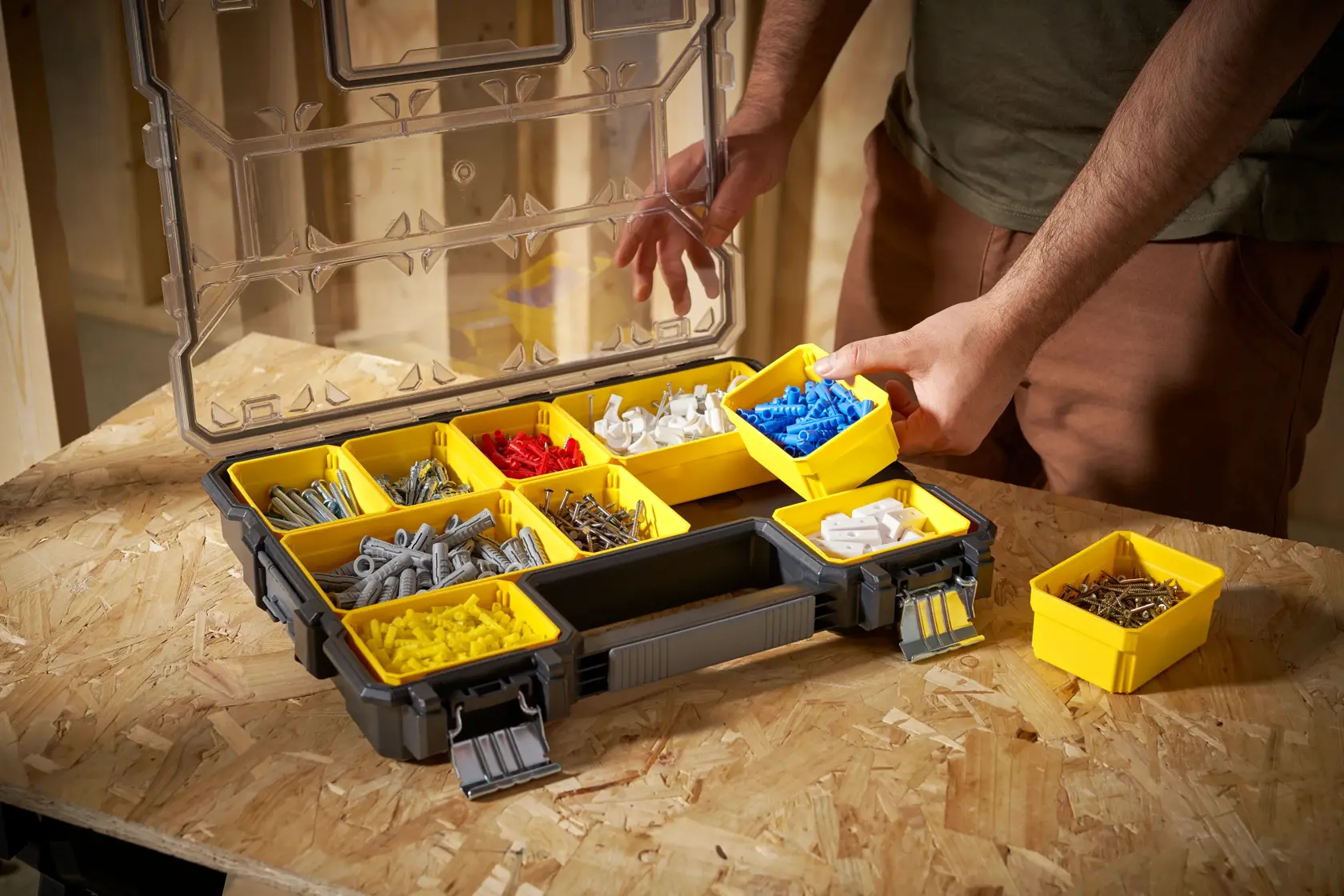 STANLEY FMST14820 organizer with yellow removable bins filled with hardware, shown on a workbench, angled view.