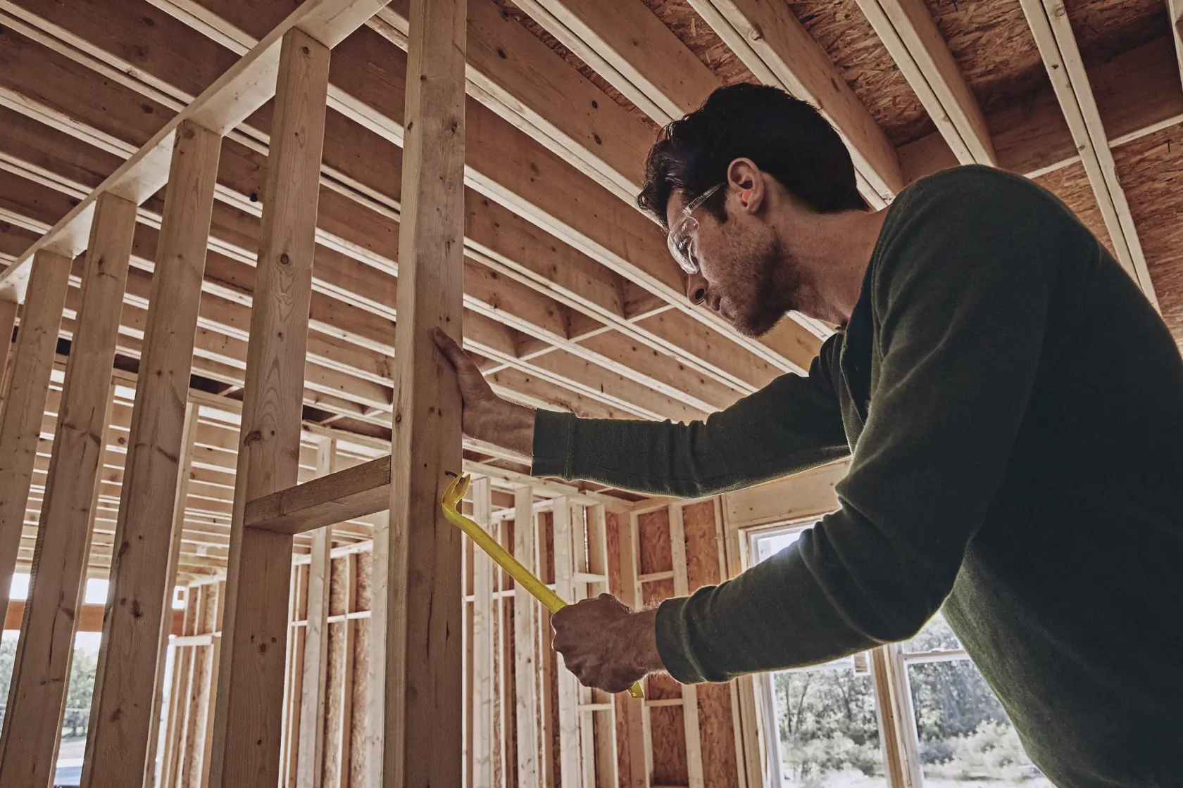 STANLEY STHT55163 wrecking bar used to pry wood framing studs in residential construction site.