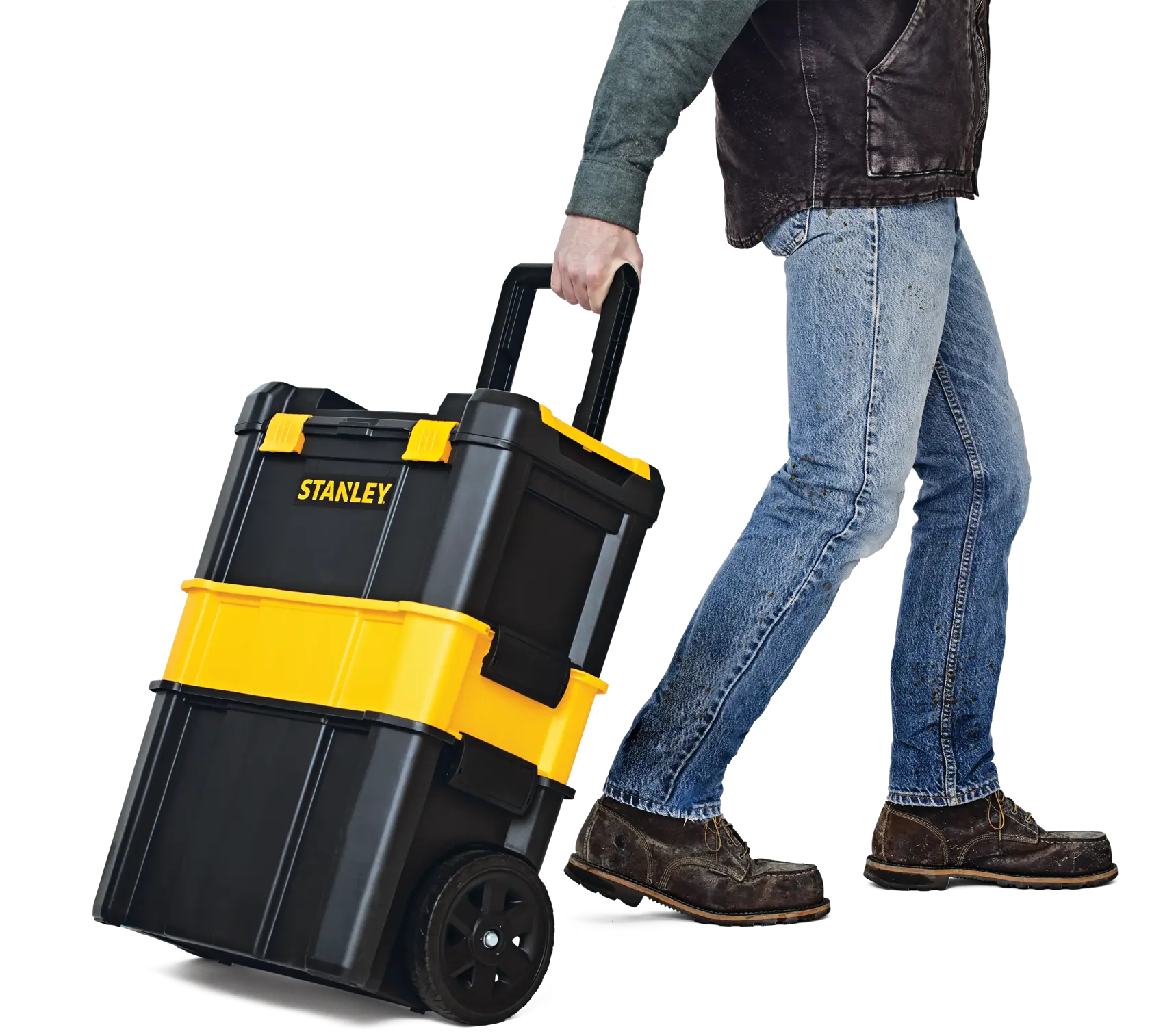 STANLEY STST18631 rolling tool box in black and yellow, shown being pulled by a person, side view.
